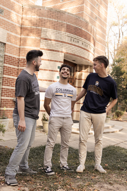 Three men standing outside a brick building, wearing Columbia International University shirts.