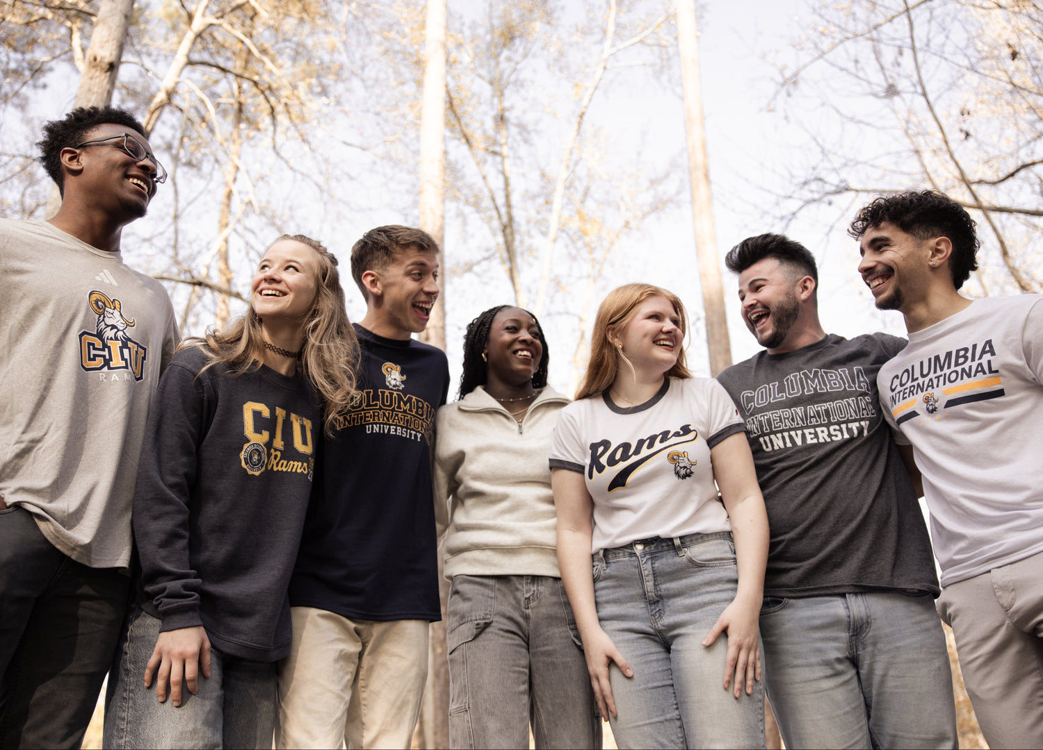 Group of people wearing Columbia International University shirts outdoors with trees in the background