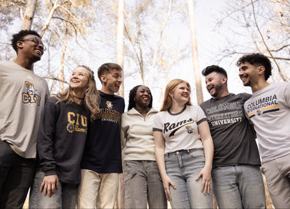 Group of people wearing Columbia International University shirts outdoors with trees in the background