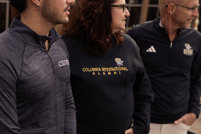 Three people standing side by side, all wearing a variety of &